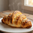 Freshly baked golden croissant with almond filling